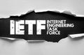 IETF Internet Engineering Task Force text below torn surface. Networking, standards, and internet governance concept linked with Royalty Free Stock Photo