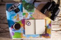 Iew of a diary, binoculars, compass, retro photo camera, coffee, and Europe map on a white wooden table