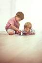 If they can do it, so can youh. two little boys using a digital tablet together while sitting on the floor. Royalty Free Stock Photo