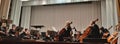 Photo conductor and musicians. Musical concert in the Philharmonic. Violin player. Music concert background