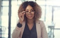 If seriousness is what you want serious is what youll get. Portrait of a young businesswoman peering over the rim of her