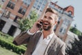 If you can dream it, you can do it. Handsome brown-haired modern businessman with beard walking in town and calling on Royalty Free Stock Photo