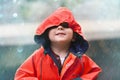 If you think the weathers cool, check me out. an adorable little boy playing outside in the rain.