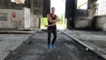 Muscular guy exercise with a jump rope in old factory.