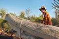 Ifaty, Madagascar - May 01, 2019: Unknown Malagasy man carrying large piece of wood on his cart pulled by zebu cattle, to be used