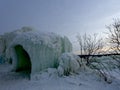 An igloo carved out of ice covered in icicles and topped with snow at Ice Castles in Lake Geneva, Wisconsin