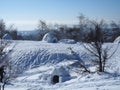 igloo and snow shelter in high snowdrift with mountains peaks on background.