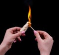 Ignite with a match in a female hand a firebrand for a fireplace on a black background Royalty Free Stock Photo