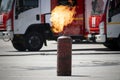 an ignited gas cylinder on background of a fire truck on the street. Danger of explosion Royalty Free Stock Photo