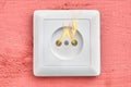 Self-ignition of household wall outlet, close-up.