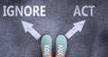 Ignore and act as different choices in life - pictured as words Ignore, act on a road to symbolize making decision and picking