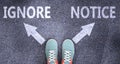 Ignore and notice as different choices in life - pictured as words Ignore, notice on a road to symbolize making decision and