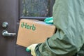 IHerb logo on a cardboard box in the hands of the courier during delivery