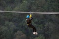 Fun, adrenaline and adventure on the zip line. Teenager having fun on a zipline on panoramic forest background Royalty Free Stock Photo