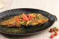 Ikan Pesmol or Pesmol Fish with Yellow Curry, Close Up on Wooden Table with Copy Space for Text