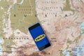 Ikea logo on the smartphone screen on the background of the map of Russia. The concept of leaving the Ikea Store from Russia. Royalty Free Stock Photo