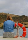 Young woman on the deck of a yacht on a blustery day Royalty Free Stock Photo