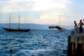 Young man jumping from the pier into the water ocean at sunset. Wearing swimsuits with friends Royalty Free Stock Photo