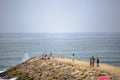 View of a big seawall on atlantic ocean and people enjoying the view and fishing