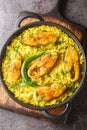 Ilish Polao or Hilsa Pulao is a Asian spicy Fish Pilaf closeup on the black pan on the table. Vertical top view Royalty Free Stock Photo