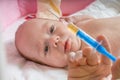 Ill baby is starring on syringe with immunization vaccine