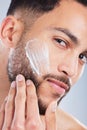 Ill be looking like a million bucks in a bit. Studio shot of a handsome young man applying a skincare product to his Royalty Free Stock Photo