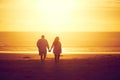 Ill always be by your side. Rearview shot of an affectionate mature couple walking hand in hand on the beach. Royalty Free Stock Photo