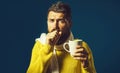 Ill bearded man with flu and fever drinking medicine tea. Handsome guy having sore throat. Sick man in sweater wrapped Royalty Free Stock Photo
