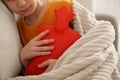 Ill boy with hot water bottle suffering from cold at home, closeup Royalty Free Stock Photo