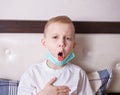 Ill boy suffering from cough in bed at home Royalty Free Stock Photo