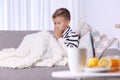 Ill boy suffering from cough on sofa Royalty Free Stock Photo