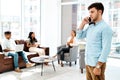 Ill call you back later, Im just in a meeting. a young businessman talking on a cellphone in an office. Royalty Free Stock Photo