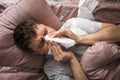 Ill caucasian young man sick with flu, cold or virus blowing running nose, got fever caught cold, sneezing in tissue Royalty Free Stock Photo