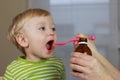 Ill child with cough syrup Royalty Free Stock Photo