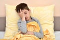 Young boy sitting in bed with headache Royalty Free Stock Photo