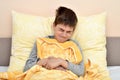 Young boy sitting in bed with stomachache Royalty Free Stock Photo