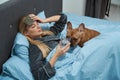Sick woman and her French bulldog in bedchamber Royalty Free Stock Photo