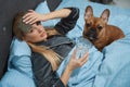 Sick woman resting in bedroom with her dog Royalty Free Stock Photo