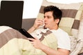 Ill guy with runny nose using laptop on the couch