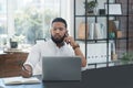 Ill make a note of that and get back to you. a young businessman talking on a cellphone while writing notes and working Royalty Free Stock Photo