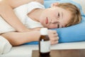 Ill male child laying down next to medicine bottle Royalty Free Stock Photo