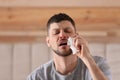 Ill man with paper tissue sneezing at home Royalty Free Stock Photo