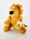 Ill plush toy lion with bandaged arm