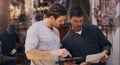 Ill send a copy to our client. two men discussing paperwork and something on a digital tablet in their workshop. Royalty Free Stock Photo