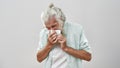 Ill senior man with cold blowing nose in napkin