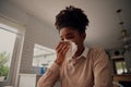 Ill sick african american woman blowing running nose got flu caught cold sneezing in tissue - working from home sick Royalty Free Stock Photo