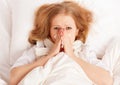 Ill sick young woman sneezes into a handkerchief in bed Royalty Free Stock Photo