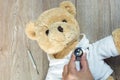 Ill teddy bear Heart stethoscope by doctor with thermometer