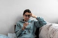 Ill upset young woman sitting on sofa covered with blanket freezing blowing running nose got fever caught cold sneezing in tissue Royalty Free Stock Photo