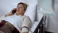 Ill woman talking on smartphone with drop counter, lying in hospital bed, health Royalty Free Stock Photo